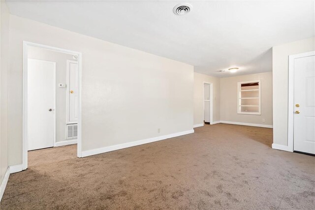 carpeted empty room featuring baseboards and visible vents