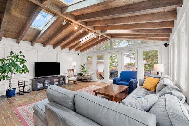 living room featuring lofted ceiling with skylight, french doors, rail lighting, and wooden ceiling