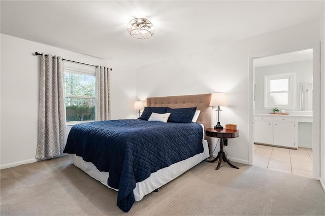 bedroom with light carpet and ensuite bath