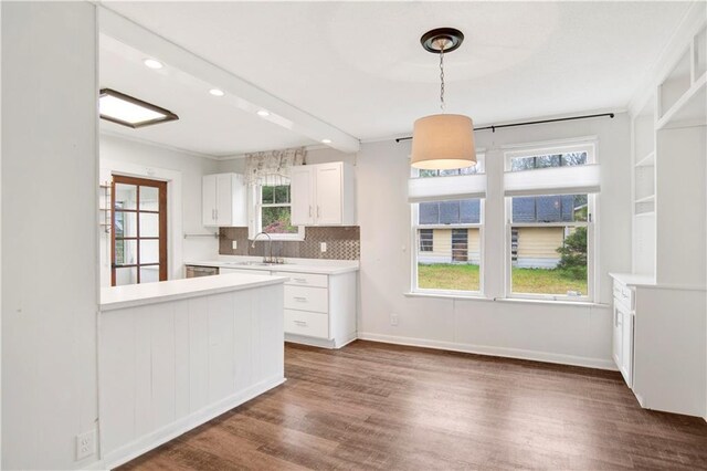 2014 Bakers Ln, Mobile, AL 36605 - kitchen featuring decorative light fixtures, white cabinets, light countertops, decorative backsplash, and dark wood-style flooring