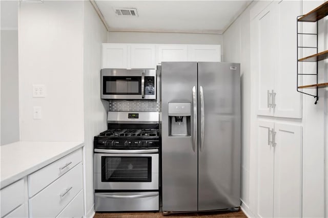 2014 Bakers Ln, Mobile, AL 36605 - kitchen with visible vents, appliances with stainless steel finishes, white cabinets, and decorative backsplash