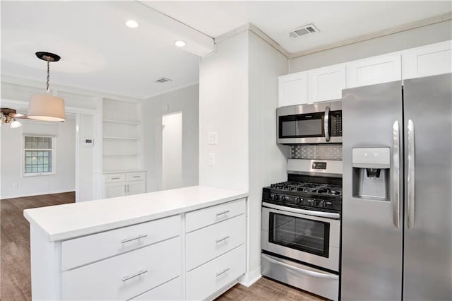 2014 Bakers Ln, Mobile, AL 36605 - kitchen with white cabinetry, a peninsula, wood finished floors, and appliances with stainless steel finishes