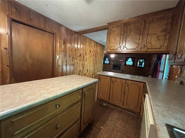 kitchen with dishwasher, wood walls, and a textured ceiling