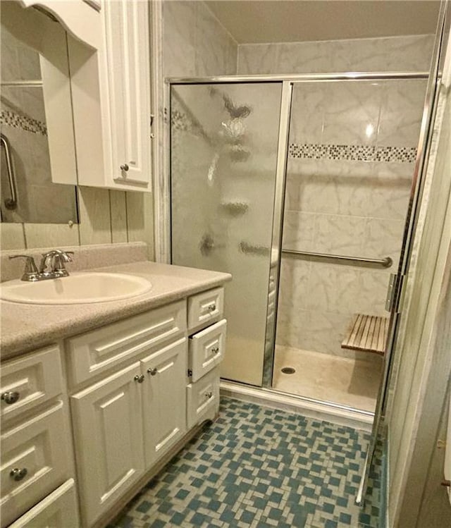 bathroom featuring tile floors, a shower with shower door, and vanity