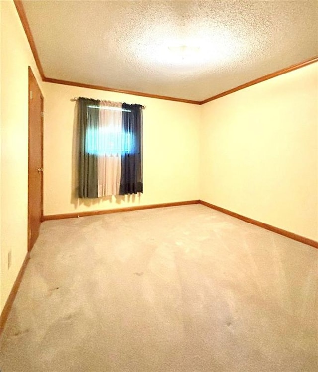 carpeted spare room with a textured ceiling and crown molding