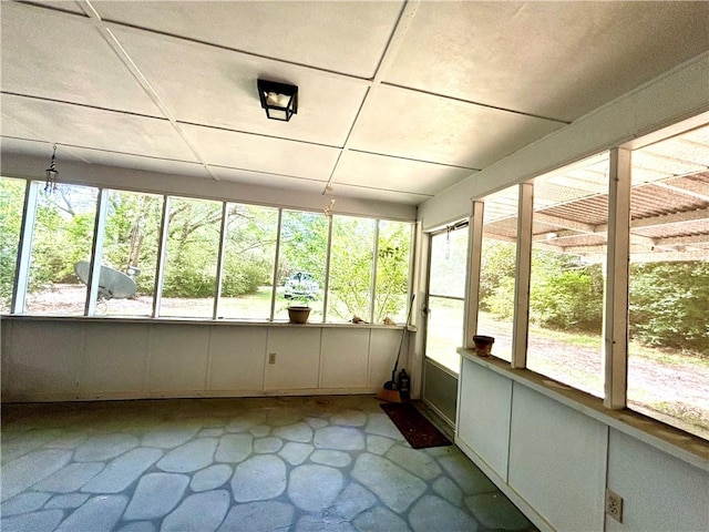 unfurnished sunroom featuring a drop ceiling