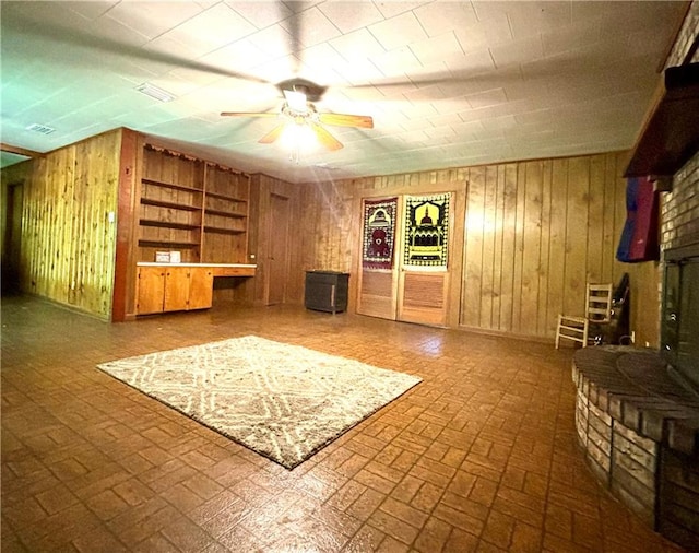 interior space featuring wood walls and ceiling fan