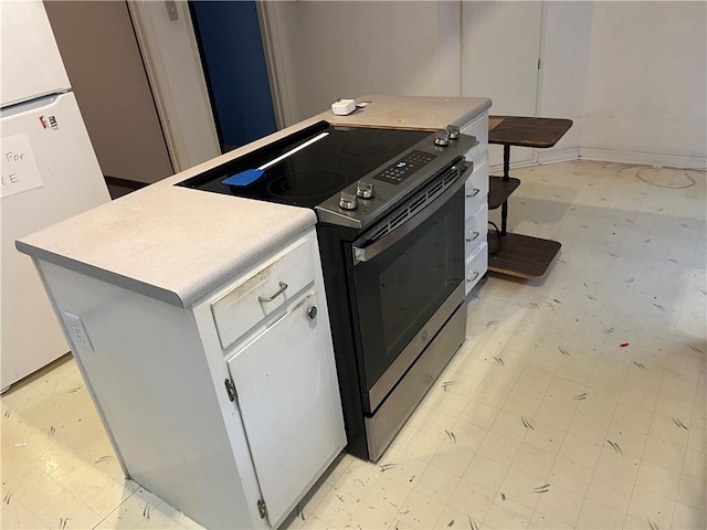 kitchen featuring white cabinetry, electric range, white refrigerator, and a kitchen island