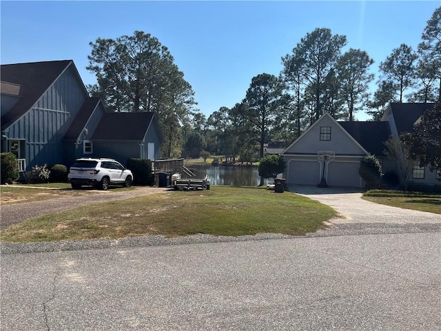 view of home's exterior with a garage, a yard, and a water view