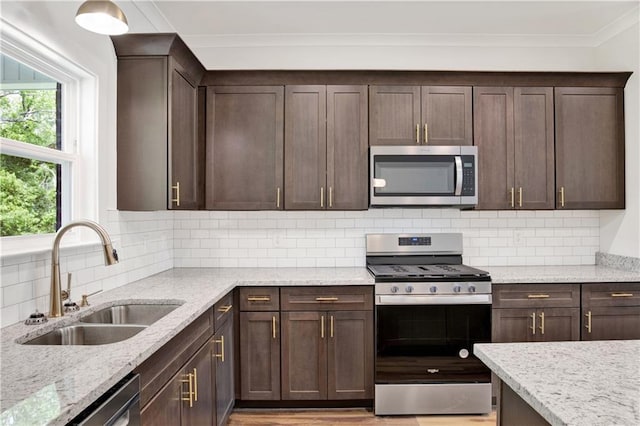 8760 Floyd Crabtree Way, Semmes, AL 36575 - kitchen with crown molding, dark brown cabinets, appliances with stainless steel finishes, light stone counters, and a sink