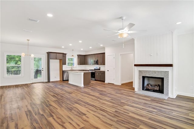 8760 Floyd Crabtree Way, Semmes, AL 36575 - kitchen with dark brown cabinets, stainless steel appliances, open floor plan, wood finished floors, and a kitchen island