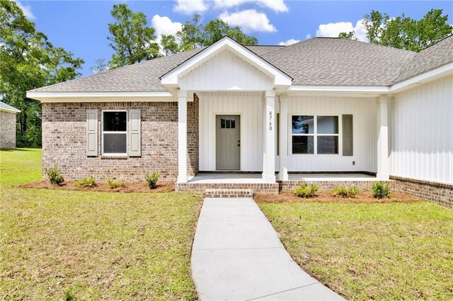 8760 Floyd Crabtree Way, Semmes, AL 36575 - single story home featuring roof with shingles, covered porch, a front yard, and brick siding