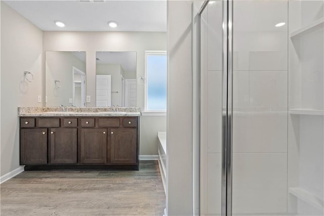 bathroom with independent shower and bath, vanity, and wood-type flooring