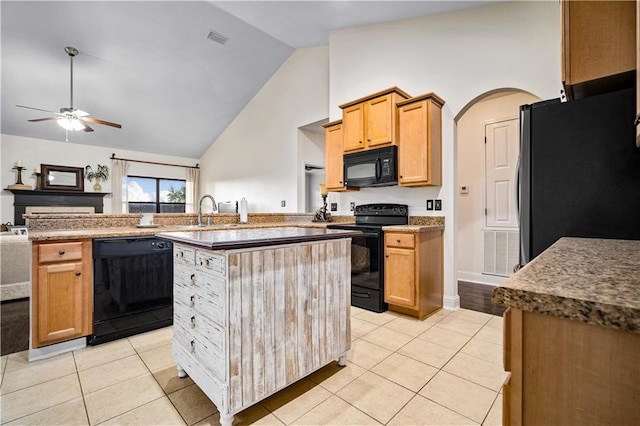 kitchen with ceiling fan, light tile patterned floors, high vaulted ceiling, a kitchen island, and black appliances