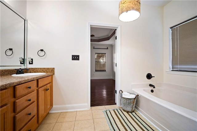 bathroom with a bathing tub, tile patterned flooring, vanity, and ornamental molding