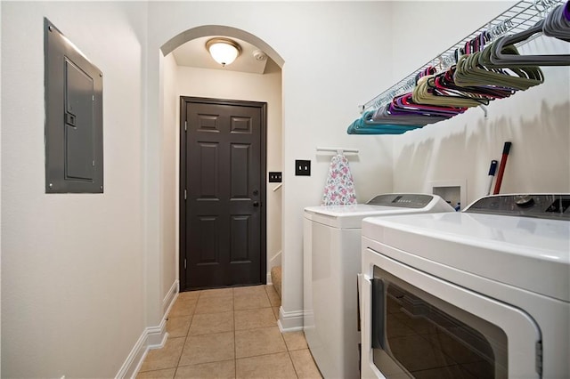 laundry room featuring electric panel, washer and clothes dryer, and light tile patterned floors