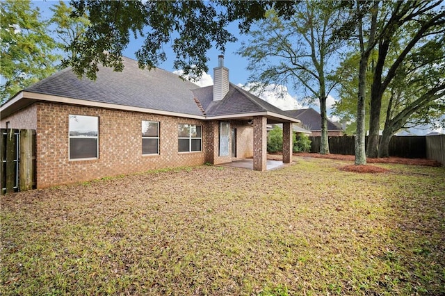 back of house with a yard and a patio