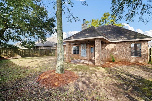 rear view of house featuring a yard and a patio