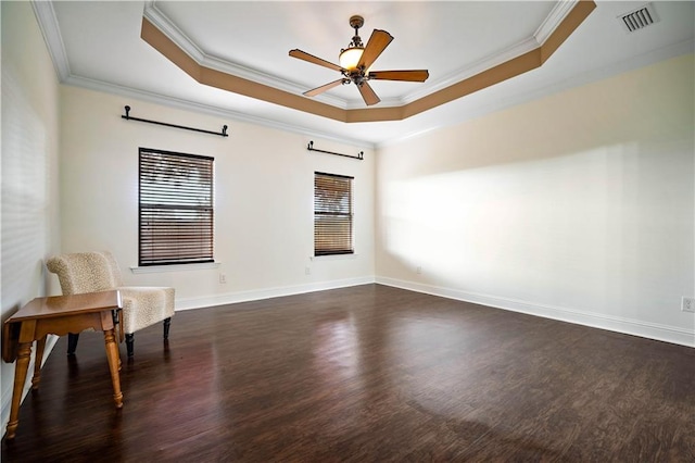 sitting room featuring ceiling fan, dark hardwood / wood-style flooring, ornamental molding, and a tray ceiling