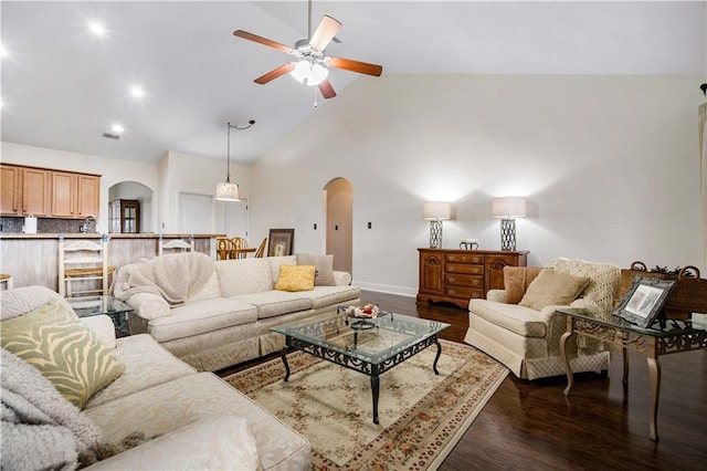 living room featuring high vaulted ceiling, ceiling fan, and dark wood-type flooring