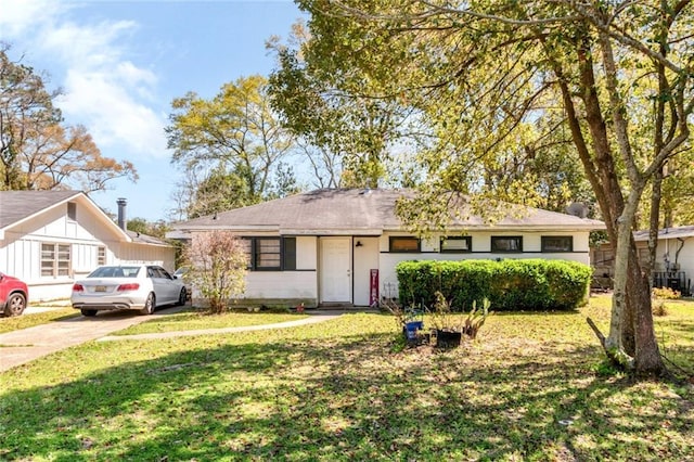 ranch-style home featuring driveway and a front yard