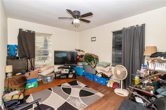 recreation room with ornamental molding, wood finished floors, and a ceiling fan