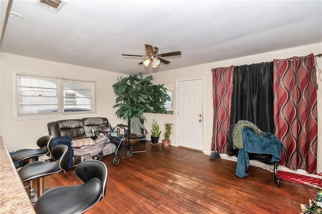 living room featuring visible vents, wood finished floors, and a ceiling fan
