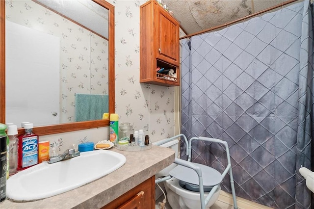 bathroom with toilet, vanity, a shower with shower curtain, and a textured ceiling