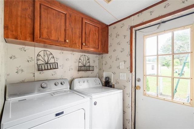 clothes washing area featuring cabinets and washing machine and clothes dryer