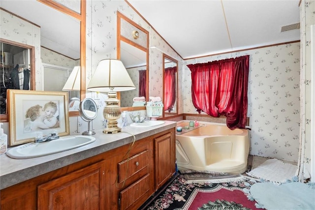 bathroom featuring vanity, lofted ceiling, and a washtub