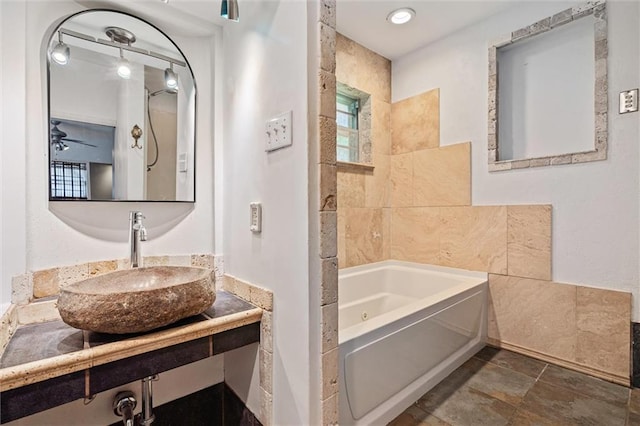 bathroom featuring vanity, a tub, and tile walls