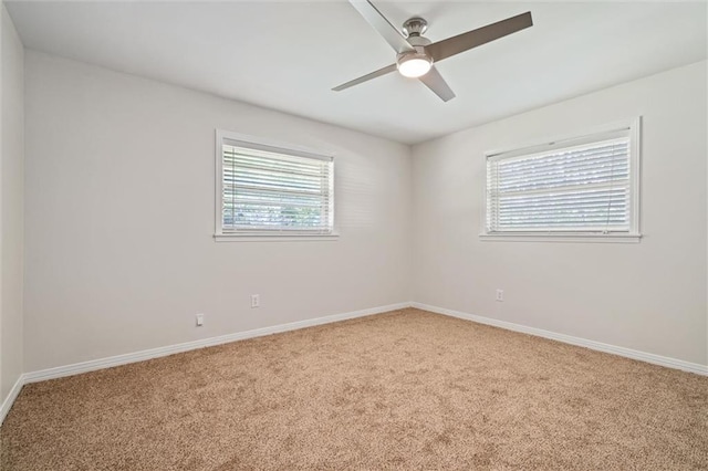 carpeted empty room with a wealth of natural light and ceiling fan