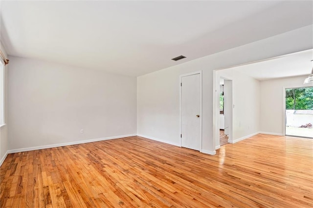 unfurnished room with an inviting chandelier and light wood-type flooring