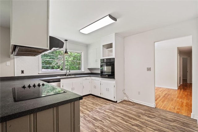 kitchen featuring light hardwood / wood-style flooring, sink, black appliances, decorative light fixtures, and white cabinetry