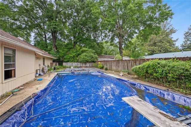 562 Vaughn Dr N, Satsuma, AL 36572 - view of swimming pool featuring a diving board, a fenced backyard, and view of scattered trees