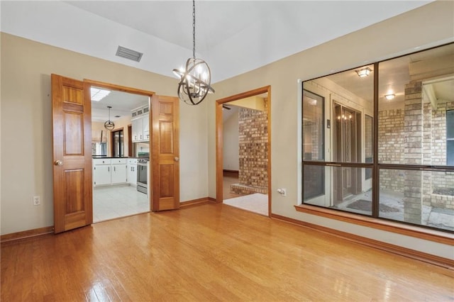 562 Vaughn Dr N, Satsuma, AL 36572 - unfurnished dining area with wood finished floors, a chandelier, and baseboards