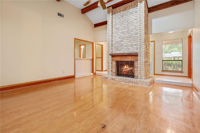 562 Vaughn Dr N, Satsuma, AL 36572 - unfurnished living room with a fireplace, high vaulted ceiling, beamed ceiling, wood finished floors, and baseboards