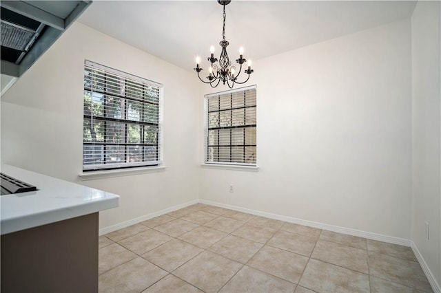 unfurnished dining area with a notable chandelier and light tile patterned floors