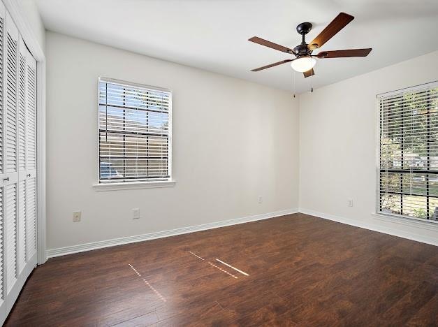 unfurnished bedroom featuring ceiling fan, a closet, and dark hardwood / wood-style floors