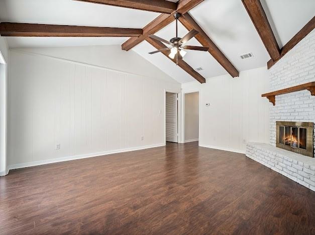 unfurnished living room with ceiling fan, a brick fireplace, vaulted ceiling with beams, and dark hardwood / wood-style flooring