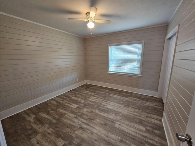 spare room featuring dark wood finished floors, baseboards, ceiling fan, and ornamental molding
