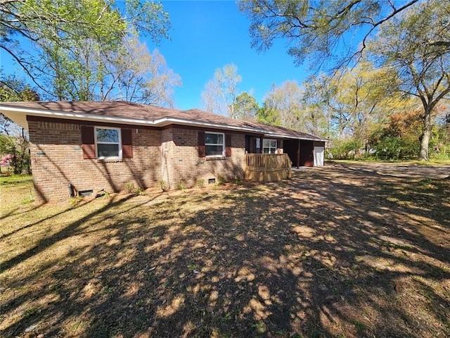 view of side of home with an attached garage, brick siding, and a yard