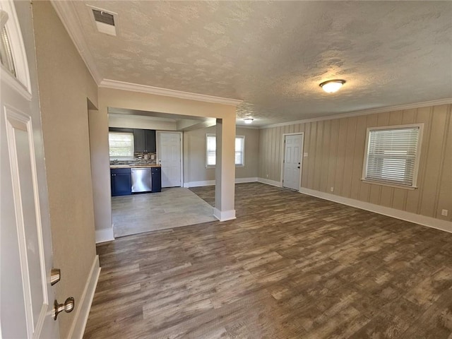entrance foyer with ornamental molding, dark wood-type flooring, a textured ceiling, and visible vents