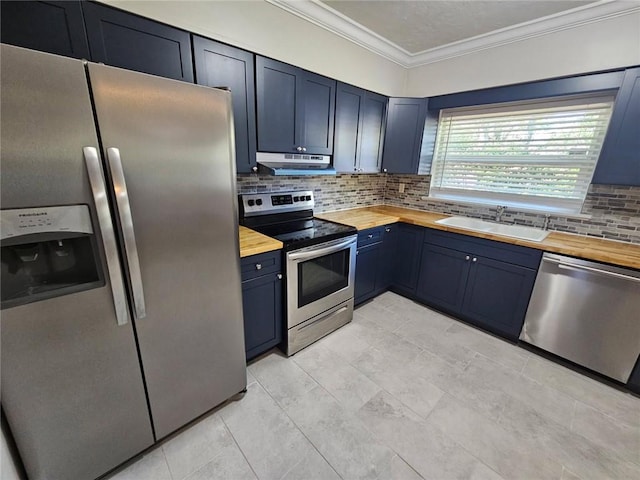 kitchen with ornamental molding, under cabinet range hood, a sink, butcher block counters, and appliances with stainless steel finishes