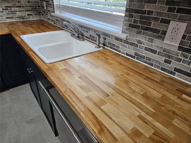 room details featuring light wood-style floors, butcher block countertops, and a sink
