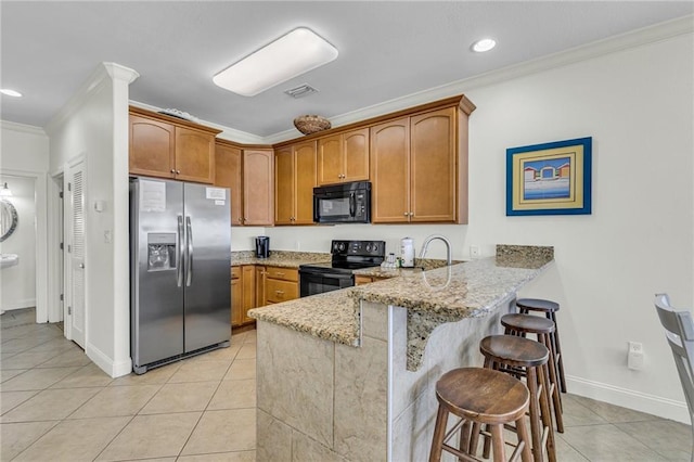 1385 Beach Blvd W, Gulf Shores, AL 36542 - kitchen with crown molding, light stone countertops, black appliances, kitchen peninsula, and light tile floors