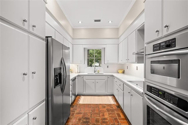 kitchen with white cabinetry, sink, crown molding, and appliances with stainless steel finishes