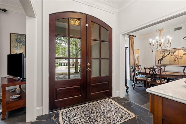 foyer entrance with a notable chandelier, dark hardwood / wood-style floors, ornamental molding, and french doors