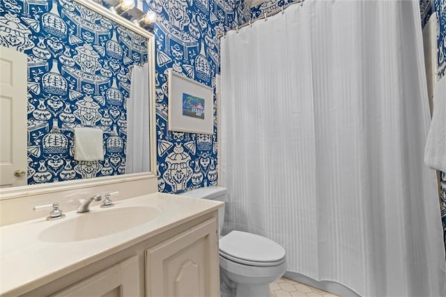 bathroom featuring tile patterned flooring, vanity, and toilet