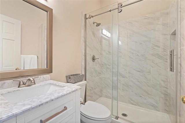 bathroom with vanity, a shower with shower door, and toilet